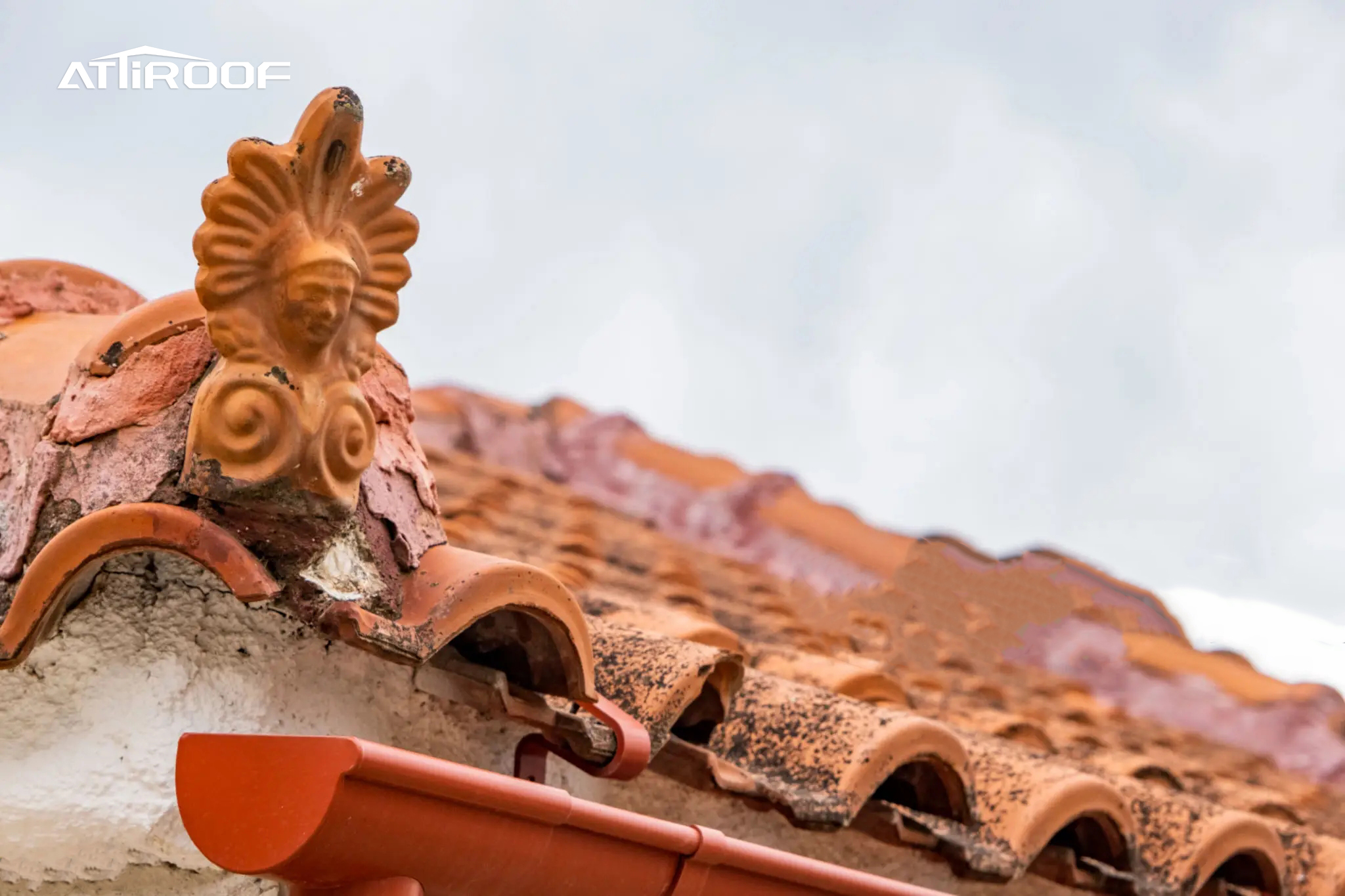 Detailed view of a terracotta ridge tile with a decorative finial on a historic building, showcasing the enduring craftsmanship of roof tiling.