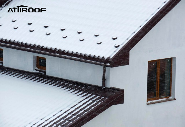 Stone-coated metal roof tiles showcasing durability as they withstand a blanket of snow, indicating weather resistance in extreme conditions.