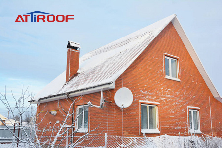 Winter scene of a cozy house with a snow-covered ATiROOF, exemplifying the roof's durability and insulation in cold weather.