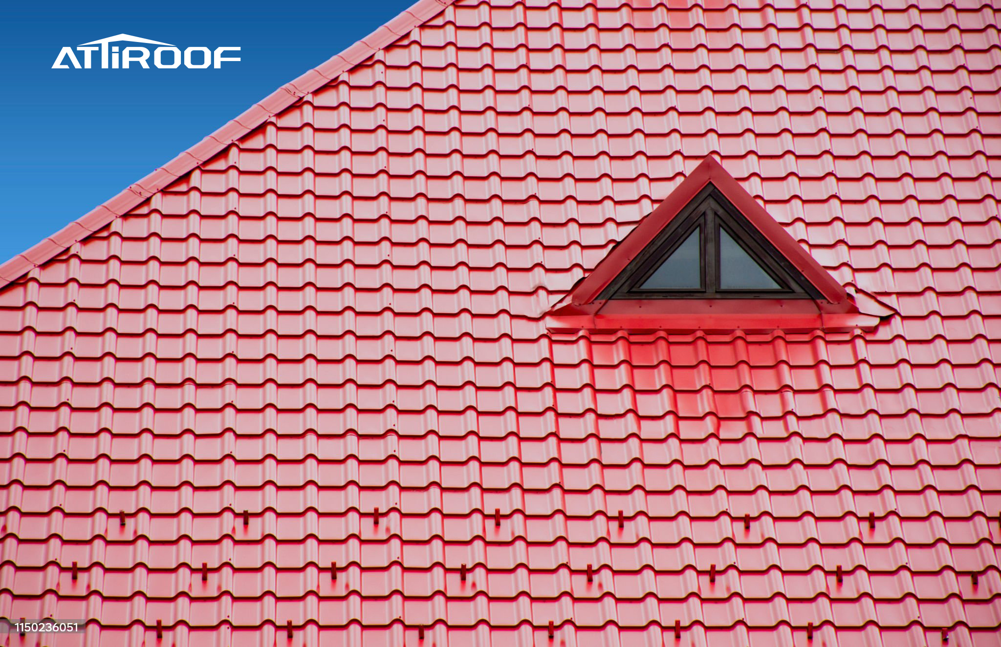 Renovated retail center with a vibrant red synthetic resin tile roof featuring a triangular dormer window against a blue sky.