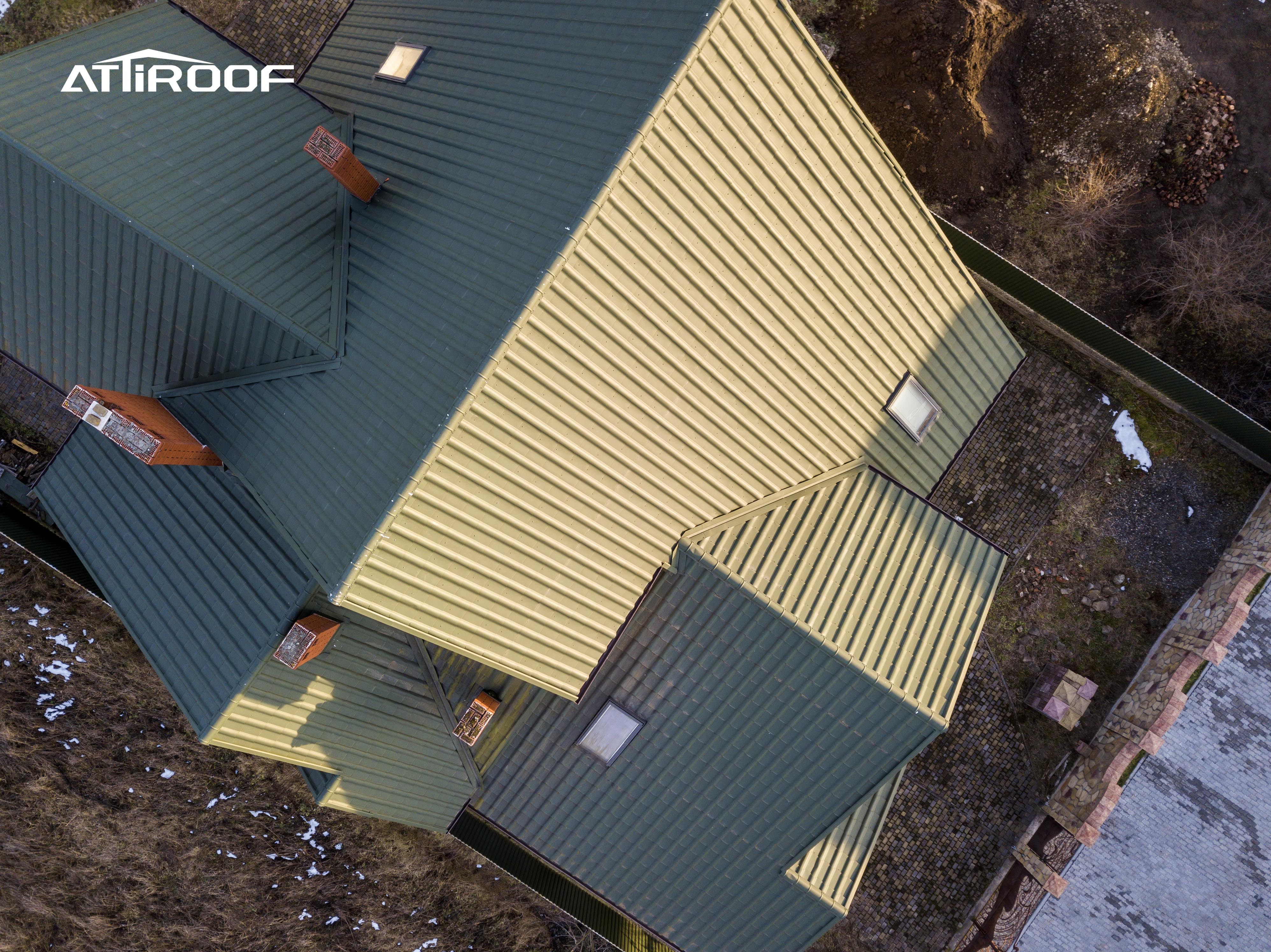 Aerial view of a building with green synthetic resin roof tiles, integrating seamlessly into the natural surroundings.