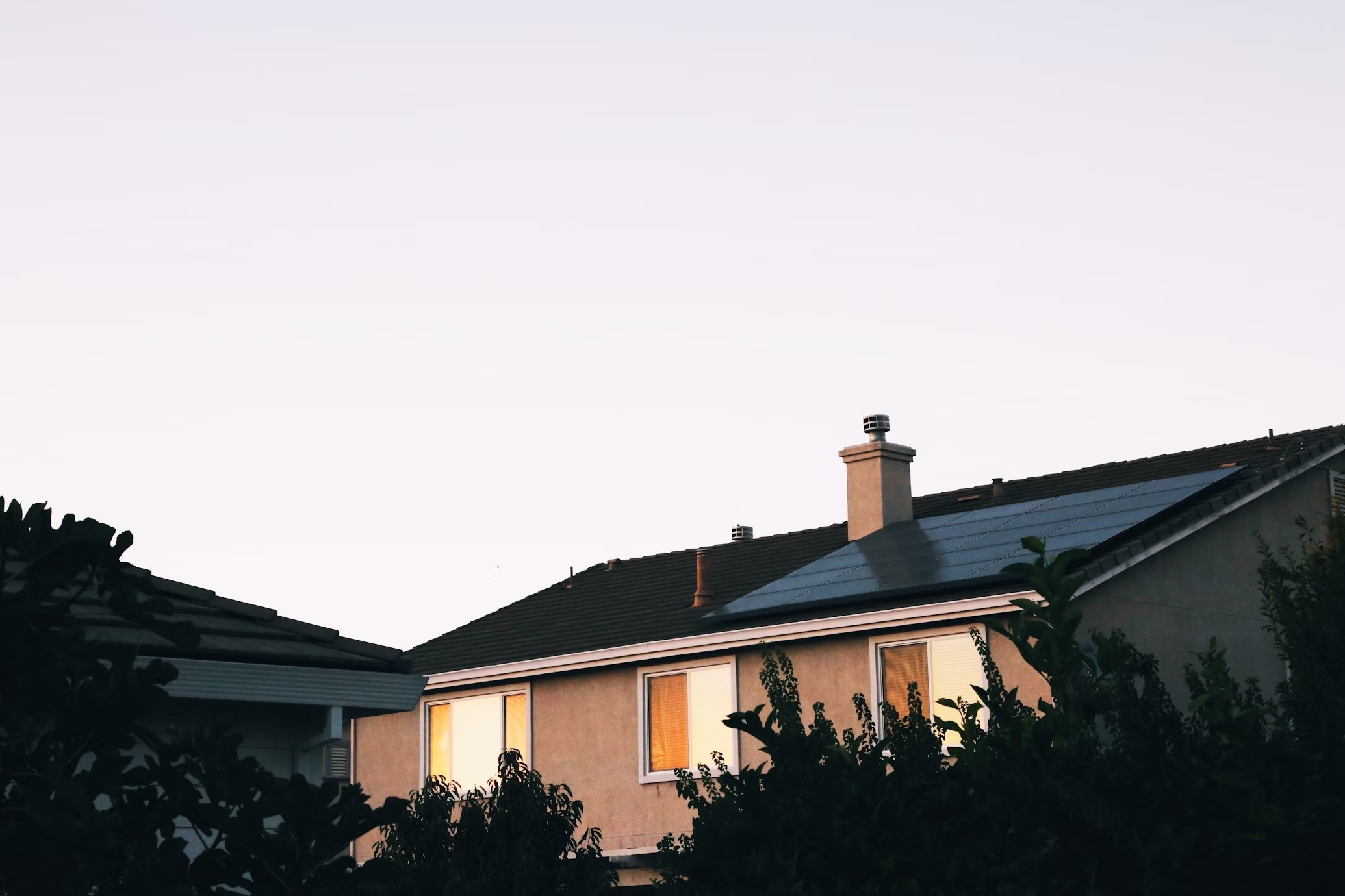 A house cleverly integrates a solar system on its roof, with tiles and solar panels perfectly integrated, showcasing a green and environmentally friendly lifestyle concept.