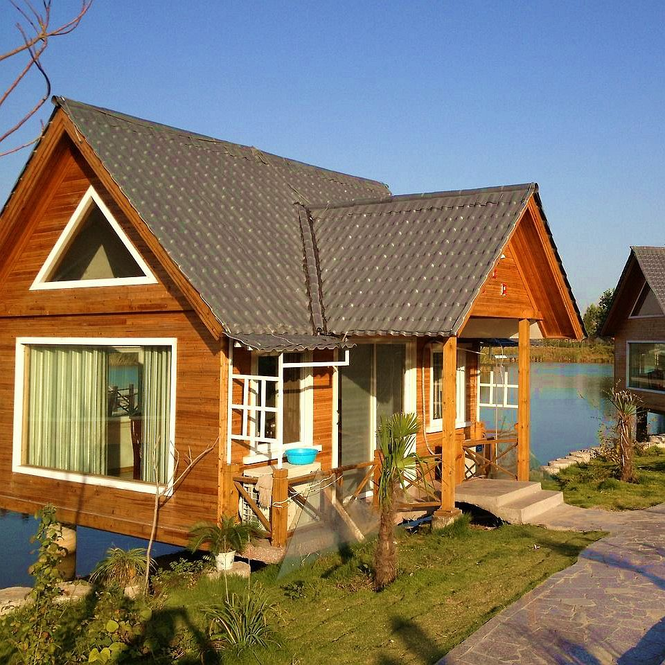 The roof of a quiet lakeside cabin in California is covered in neat, textured grey resin tiles.