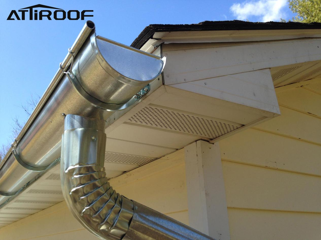 The steel drainage system extends from the corner of the roof, and silver metal pipes bend down along the wall.