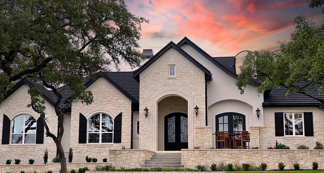 A modern style house with light colored bricks or stones on the exterior walls and black colored stone tiles on the roof.